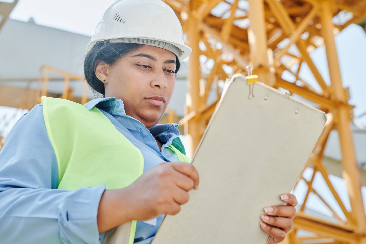 Person mit Schreibbrett bei der Aufnahme auf einer Baustelle
